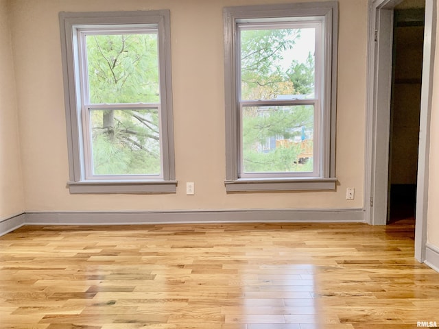 empty room with light wood-type flooring and baseboards