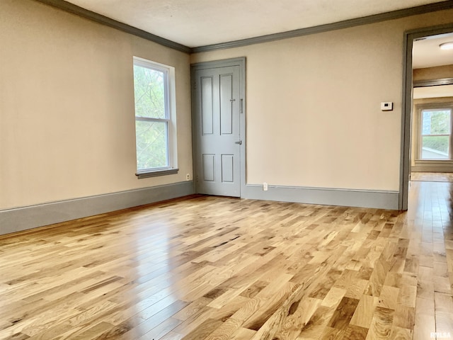 spare room featuring ornamental molding, wood finished floors, and baseboards