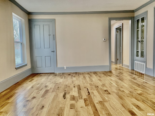 unfurnished room with light wood-type flooring, plenty of natural light, and ornamental molding