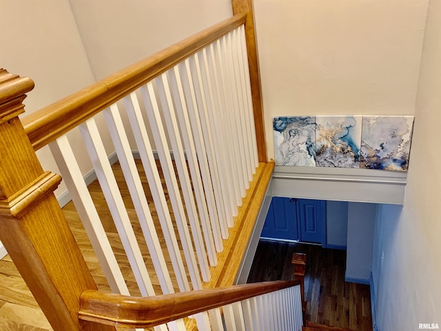 stairway with baseboards and wood finished floors