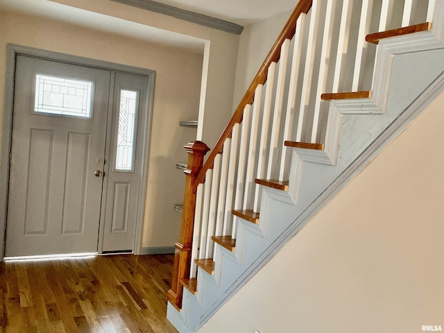 foyer with stairs, baseboards, and wood finished floors