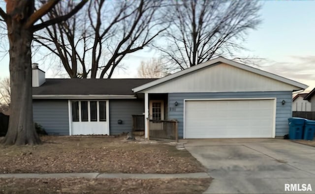 ranch-style house with an attached garage, a chimney, and concrete driveway