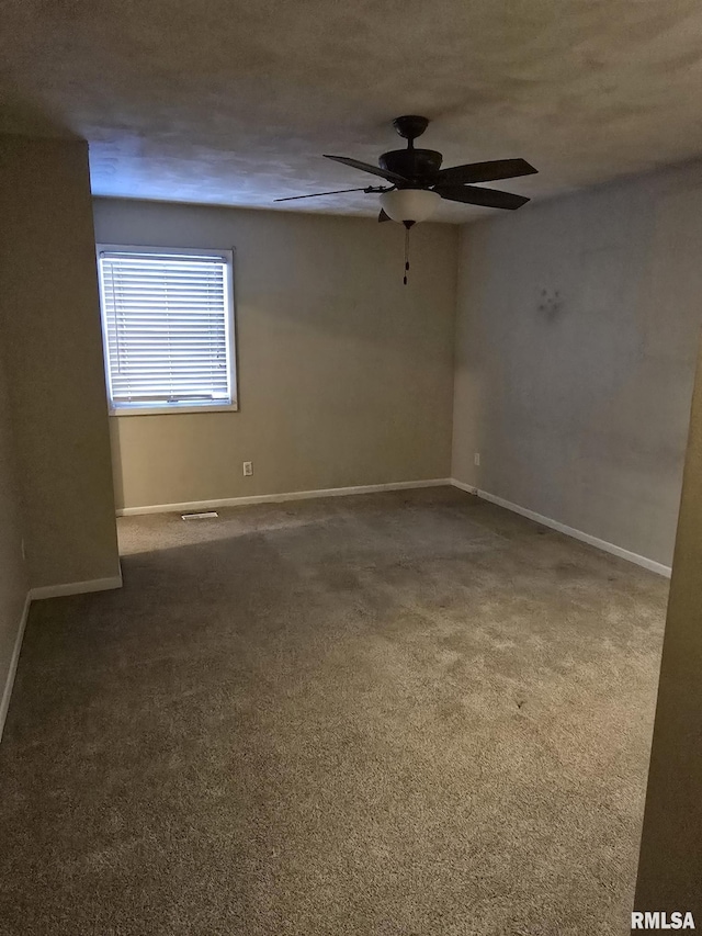 carpeted spare room featuring ceiling fan, baseboards, and a textured ceiling