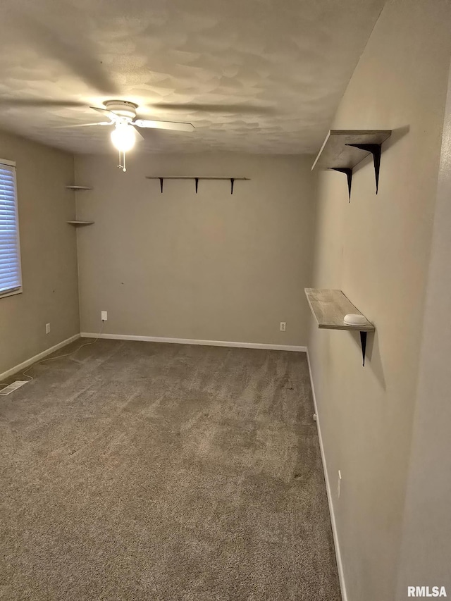 carpeted empty room with visible vents, ceiling fan, and baseboards