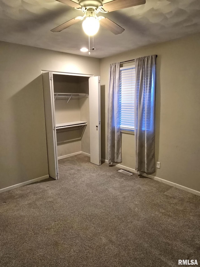 unfurnished bedroom with carpet flooring, ceiling fan, visible vents, and baseboards