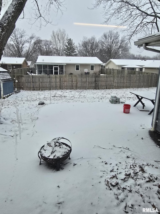 yard covered in snow with a fenced front yard