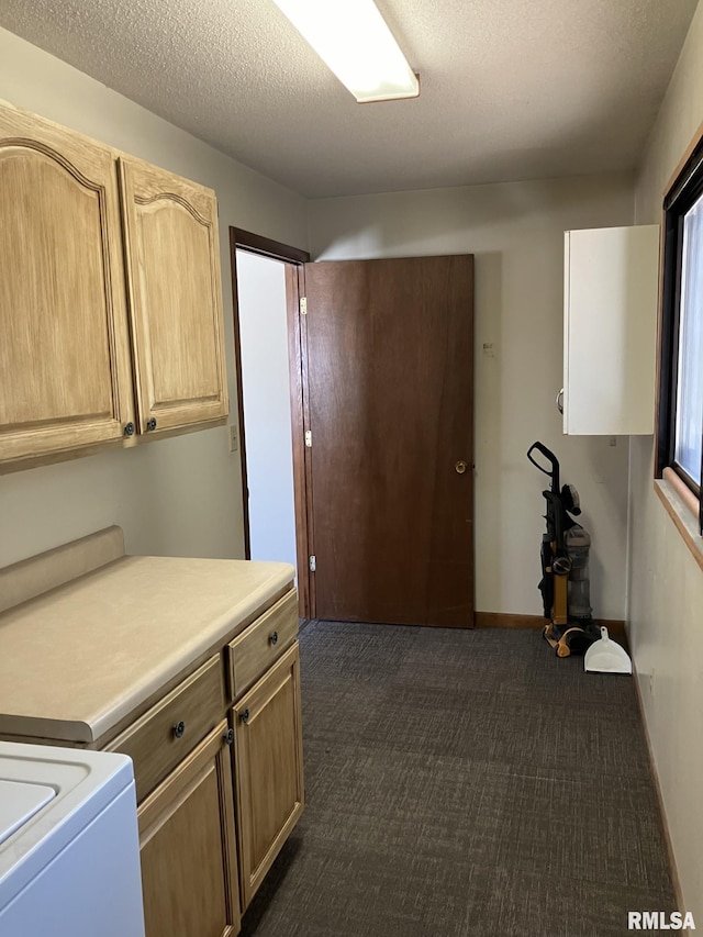 laundry room featuring cabinet space, baseboards, dark carpet, and a textured ceiling