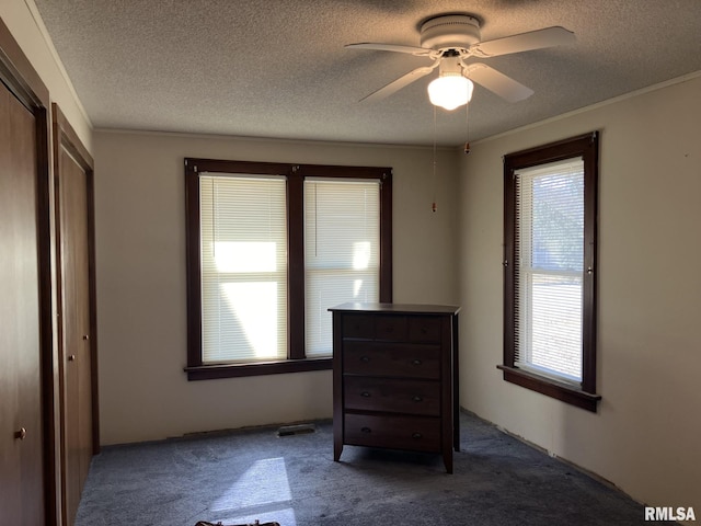 bedroom featuring a textured ceiling, carpet floors, and a ceiling fan