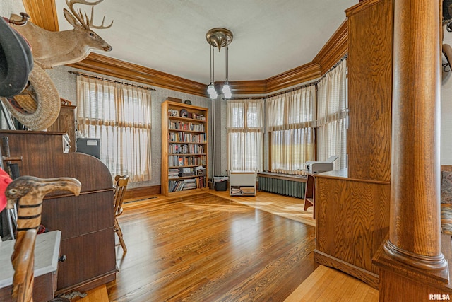 office space featuring crown molding, radiator heating unit, and wood finished floors