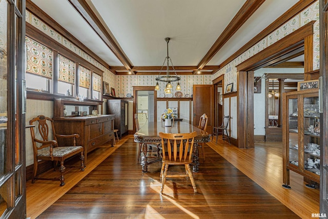 dining room with baseboards, beam ceiling, wallpapered walls, dark wood finished floors, and crown molding