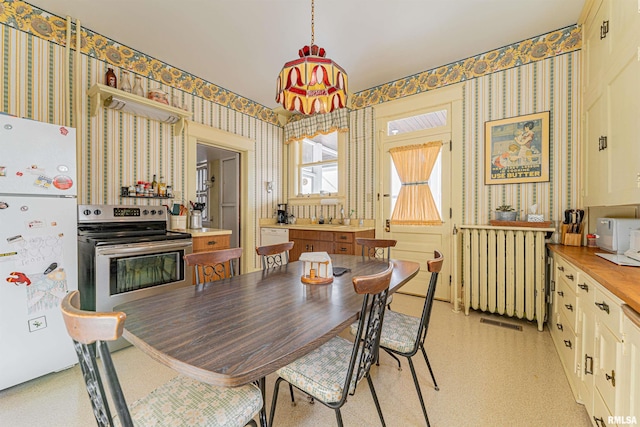 dining area with visible vents, radiator heating unit, and wallpapered walls