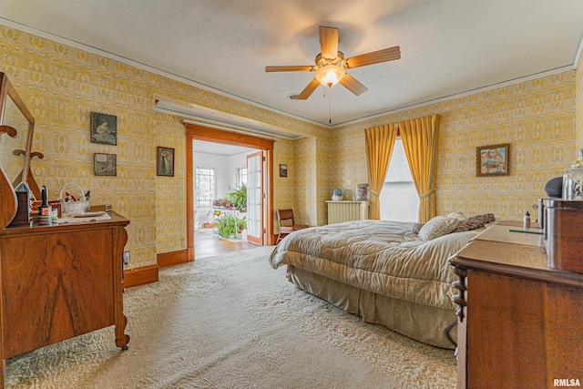 carpeted bedroom with baseboards, ceiling fan, ornamental molding, and wallpapered walls
