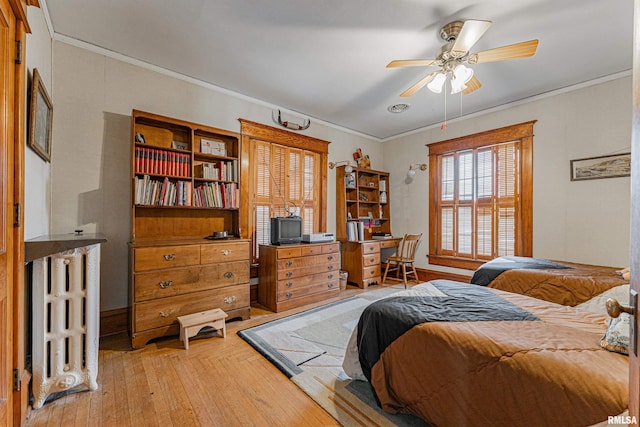 bedroom featuring light wood-style floors, ceiling fan, and crown molding