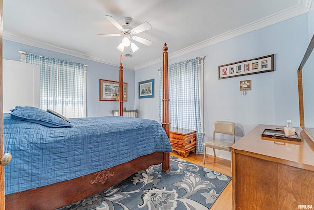 bedroom with wood finished floors, a ceiling fan, and crown molding
