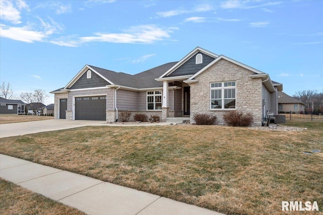 craftsman-style home featuring stone siding, concrete driveway, fence, and a front yard