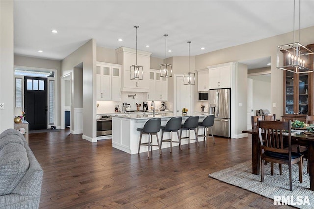 kitchen featuring dark wood finished floors, a notable chandelier, light countertops, appliances with stainless steel finishes, and open floor plan