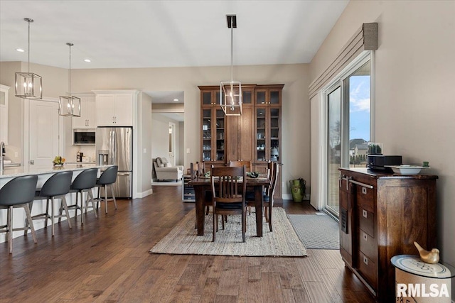 dining room with baseboards, a chandelier, dark wood finished floors, and recessed lighting