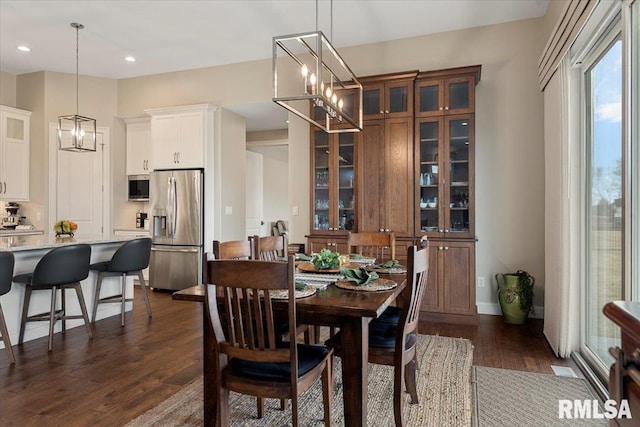 dining room with a chandelier, recessed lighting, and dark wood-type flooring