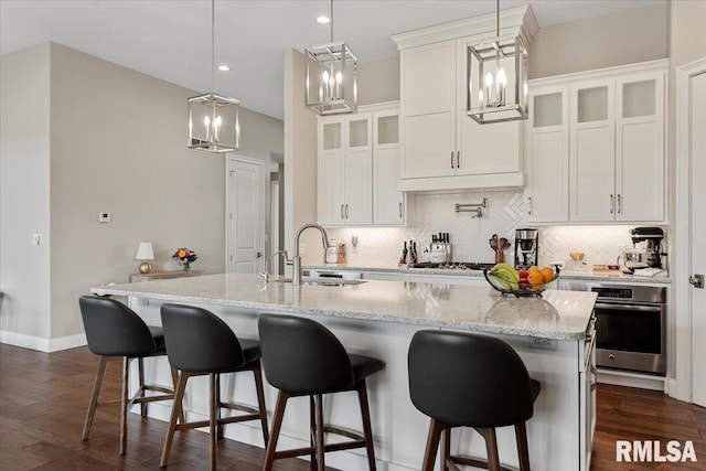 kitchen featuring dark wood-style flooring, appliances with stainless steel finishes, backsplash, and a sink