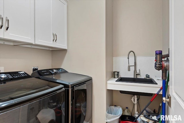 washroom with cabinet space, a sink, and separate washer and dryer