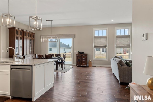 kitchen with a notable chandelier, a sink, white cabinets, open floor plan, and dishwasher