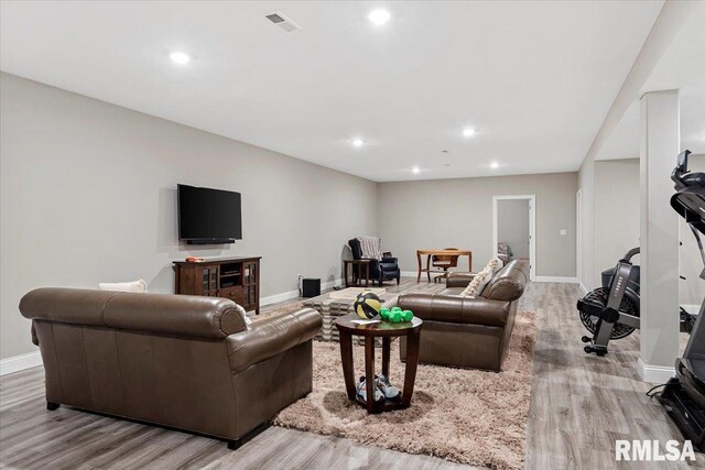 living room with visible vents, baseboards, wood finished floors, and recessed lighting