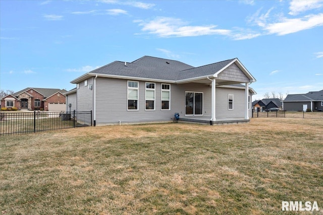 rear view of house featuring a yard and fence