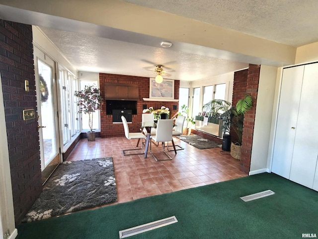 carpeted entrance foyer featuring tile patterned flooring, a fireplace, and a textured ceiling