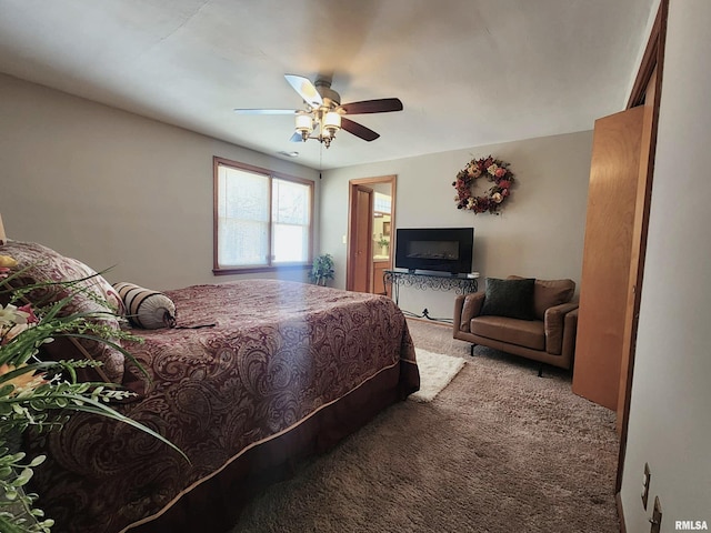 carpeted bedroom featuring a ceiling fan and connected bathroom