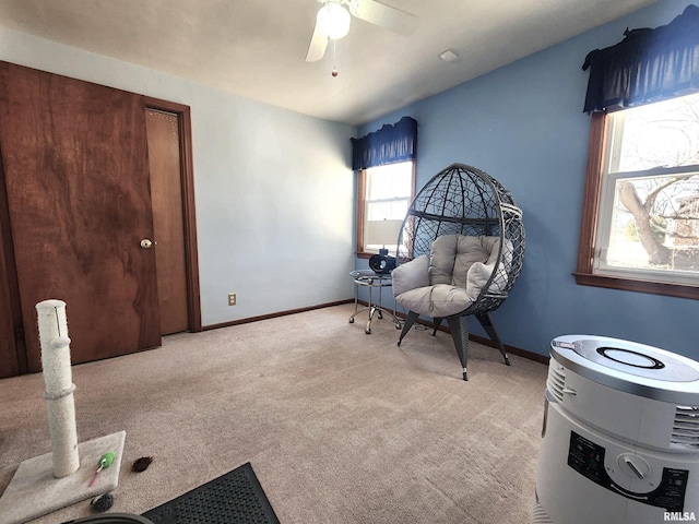 sitting room with light carpet, baseboards, and a ceiling fan