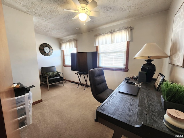 office space with a textured ceiling, carpet floors, a ceiling fan, and baseboards