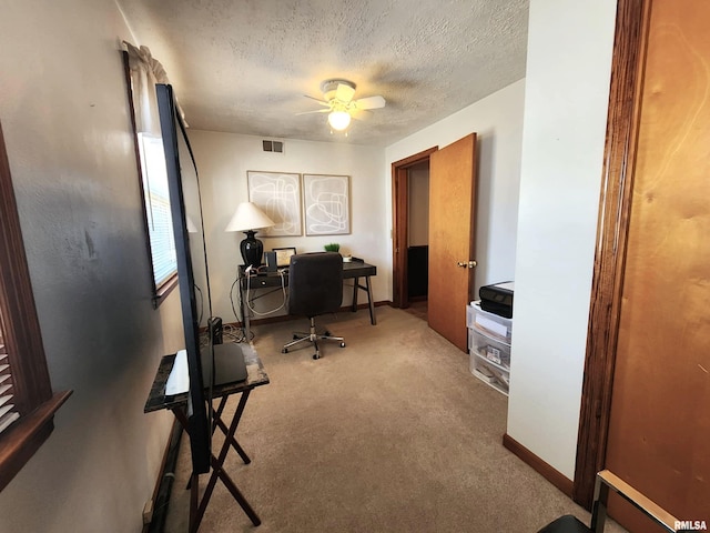 office area featuring carpet, visible vents, a ceiling fan, a textured ceiling, and baseboards