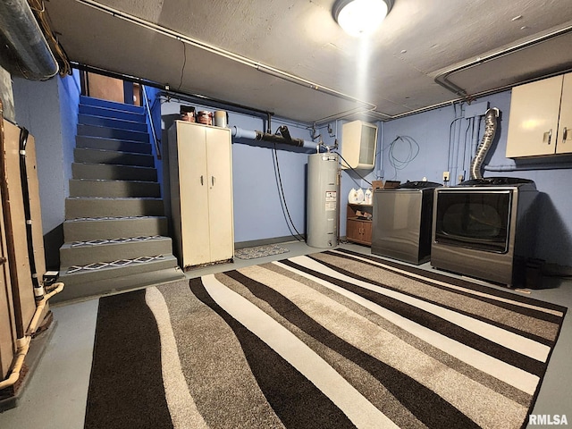 finished basement featuring washer and dryer, water heater, and stairs