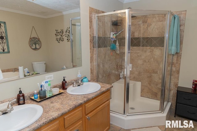 bathroom with double vanity, a shower stall, ornamental molding, and a sink