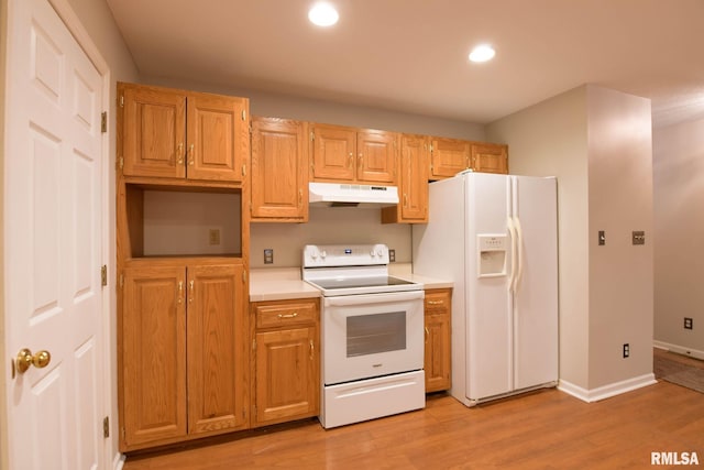 kitchen featuring recessed lighting, under cabinet range hood, white appliances, light countertops, and light wood-type flooring