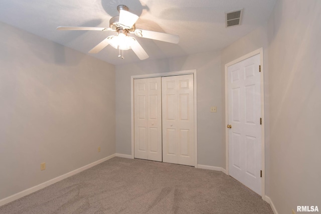 unfurnished bedroom with carpet floors, a closet, visible vents, ceiling fan, and baseboards