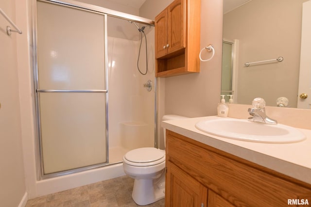 full bathroom featuring vanity, a shower stall, and toilet