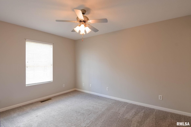 carpeted empty room featuring baseboards, visible vents, and a ceiling fan