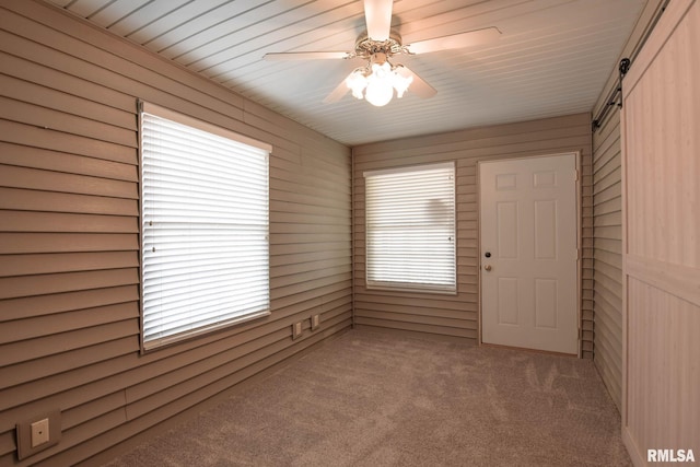 carpeted empty room with a ceiling fan