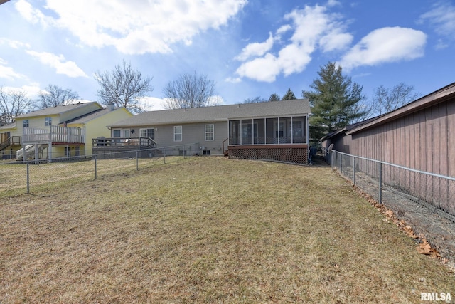 back of property featuring a sunroom, a fenced backyard, and a lawn