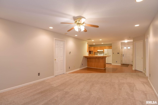 unfurnished living room with light carpet, ceiling fan, baseboards, and recessed lighting