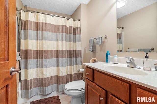 full bathroom featuring a textured ceiling, a shower with shower curtain, vanity, and toilet