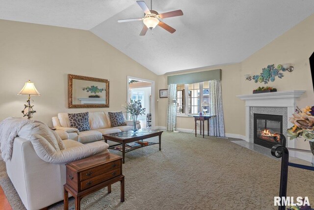 carpeted living room featuring lofted ceiling, ceiling fan, baseboards, and a high end fireplace