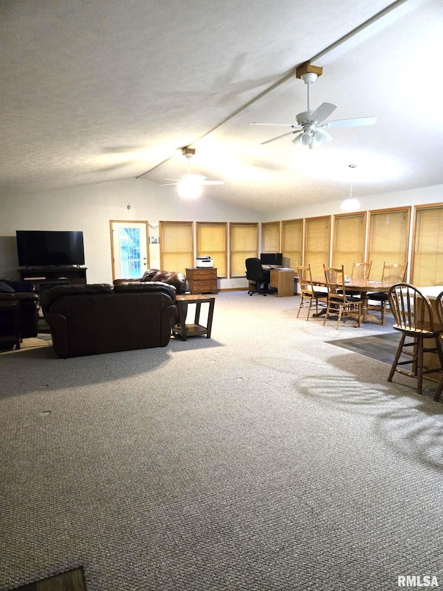 living area featuring vaulted ceiling, ceiling fan, and carpet flooring