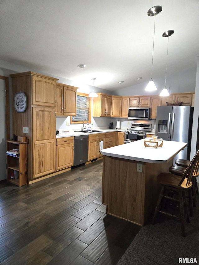 kitchen with stainless steel appliances, dark wood-style flooring, vaulted ceiling, hanging light fixtures, and light countertops