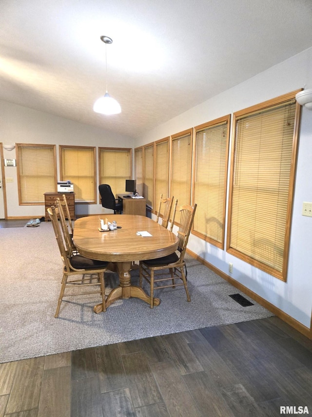 dining space featuring vaulted ceiling, dark wood-type flooring, visible vents, and baseboards