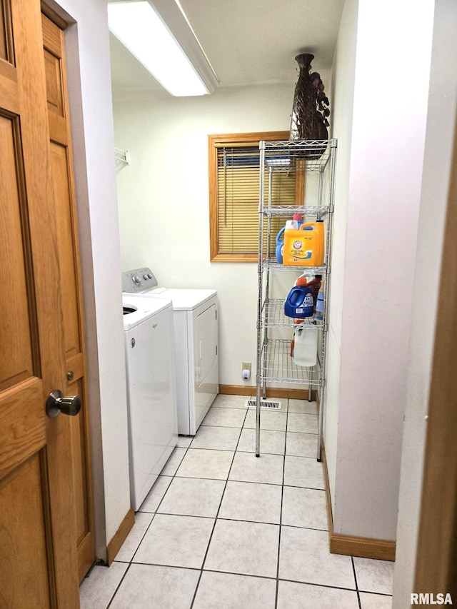 washroom with laundry area, baseboards, separate washer and dryer, and light tile patterned floors