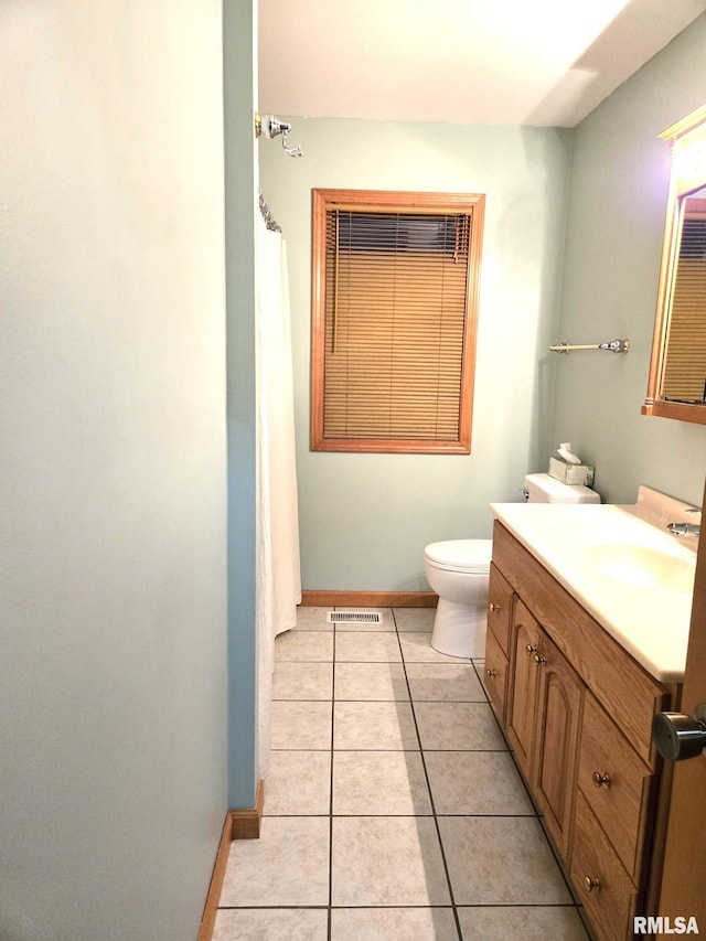 bathroom featuring visible vents, toilet, vanity, baseboards, and tile patterned floors