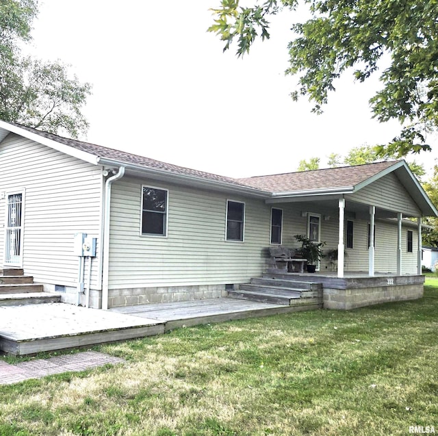 view of front of home featuring entry steps, roof with shingles, and a front yard