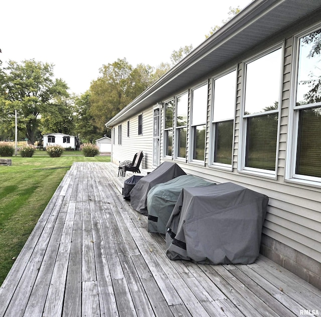 wooden terrace featuring a lawn and grilling area